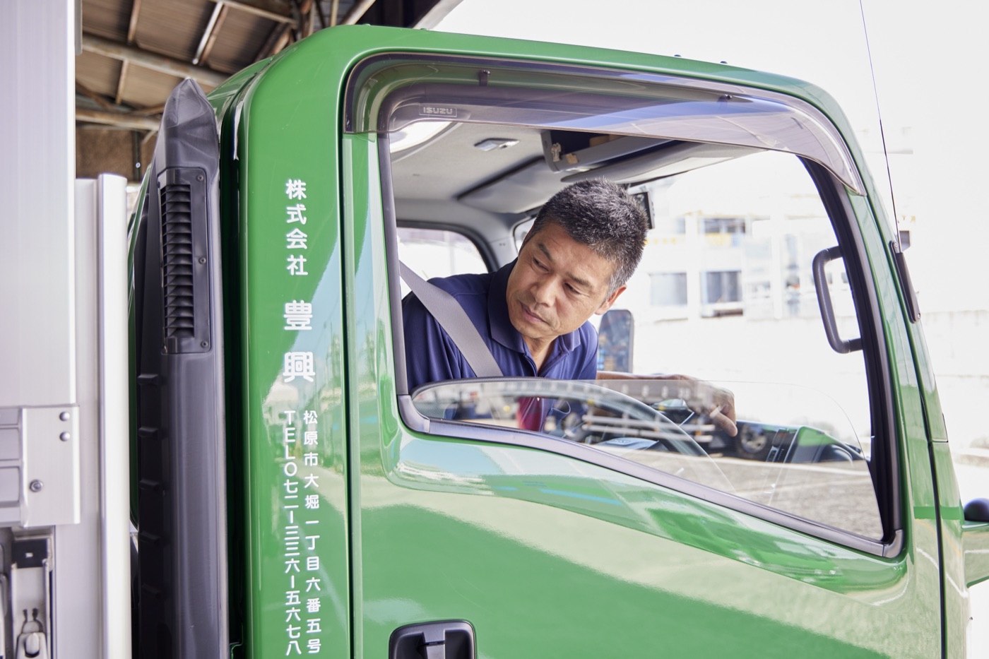運転席まわりで発車前の確認をするドライバー(自社スタッフ)
