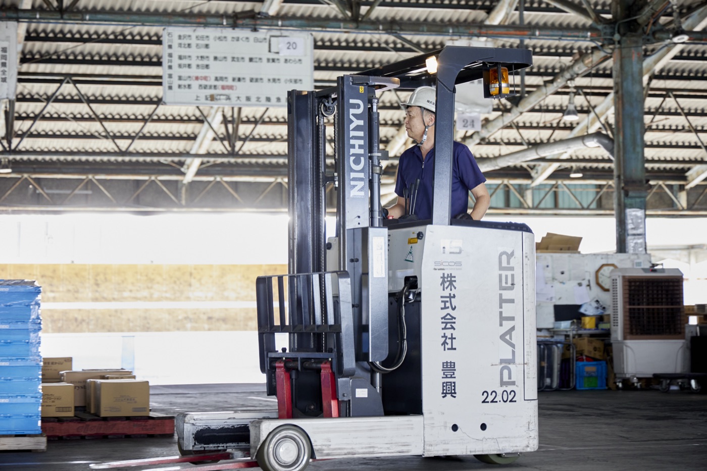フォークリフトでパレットを扱うHOKOのスタッフ(自社センター)